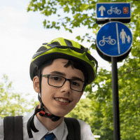 Portrait of young boy in bike helmet smiling.