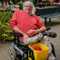 Gordon sitting in his mobility scooter with a basket of shopping