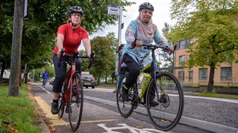 Two women cycling together on a segregated cycle lane