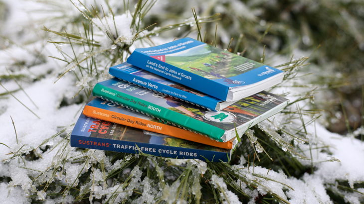 Guidebooks arranged beneath a Christmas tree. The guidebooks are: Traffic-free cycle rides, Circular day rides South, Circular Day Rides North, Land's End to John O'Groats, Avenue Verte,