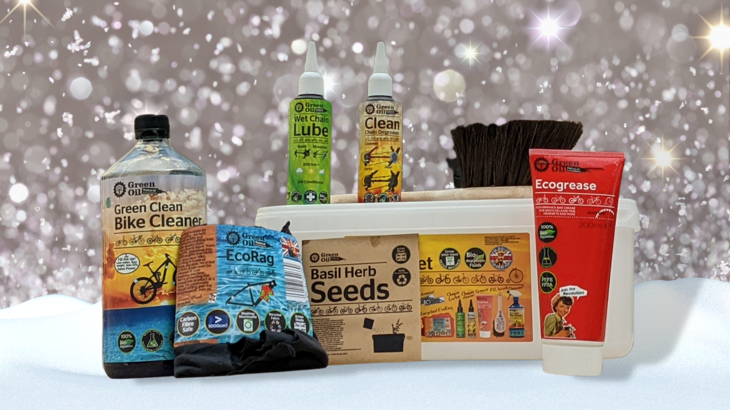 Green Oil Eco Rider Deluxe set arranged on snow with a sparkly background.