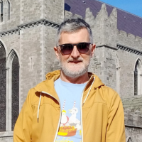 A man with sunglasses stood outside a church.