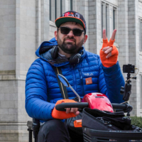 Man in mobility scooter making peace sign.