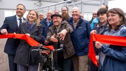 A group of people including Sustrans Scotland Director Karen McGregor and Patrick Harvie MSP cut a red ribbon to open the Gourock project