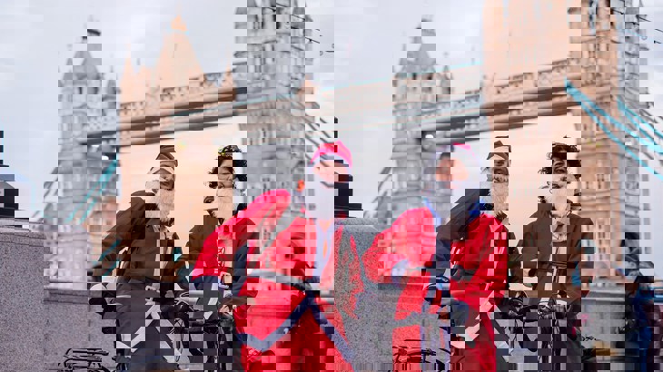 Santas with bikes in front of Tower Bridge