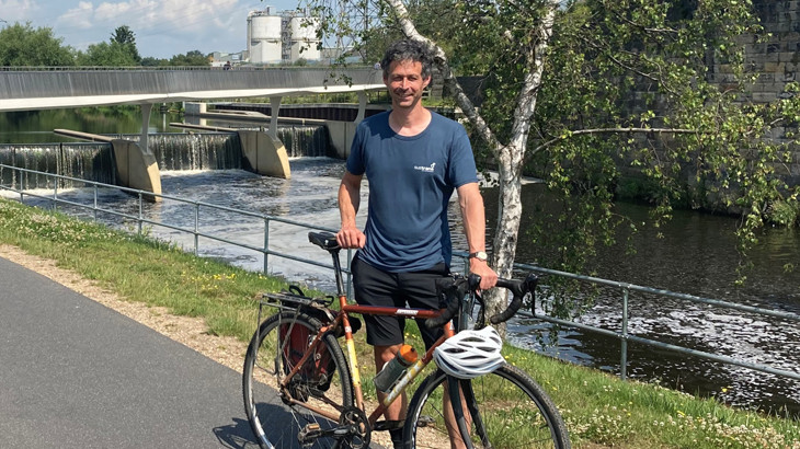 Sustrans Network Development Manager, Mike Babbit, standing with his bicycle on a traffic-free route.